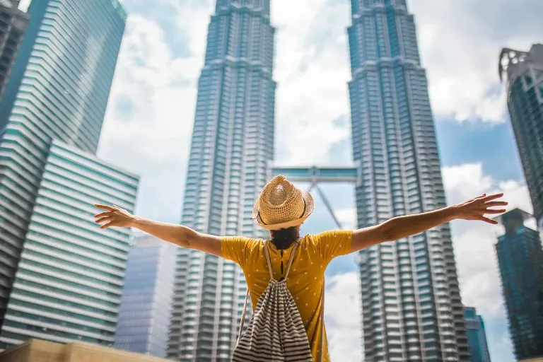 Woman admiring the Patronas Twin Tower From a low angle