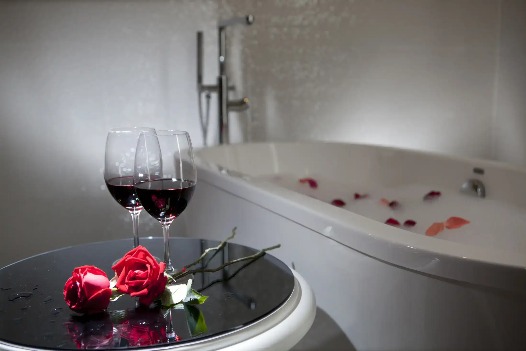 Wine glasses and roses by the bathtub at Silka Cheras Suite