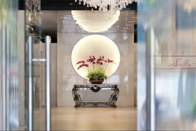 Lobby with mirror and flower vase at Silka Maytower Hotel