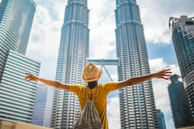 Woman admiring the Patronas Twin Tower From a low angle