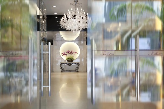 Lobby with mirror and flower vase at Silka Maytower Hotel