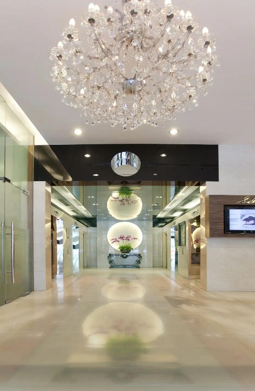 Lobby with mirror and flower vase at Silka Maytower Hotel