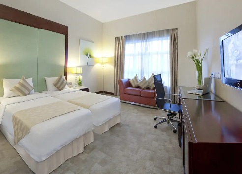 Twin beds, work desk, and city view at Silka Maytower Deluxe Room