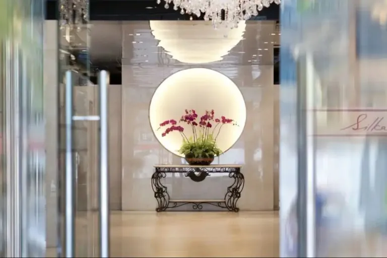 Lobby with mirror and flower vase at Silka Maytower Hotel