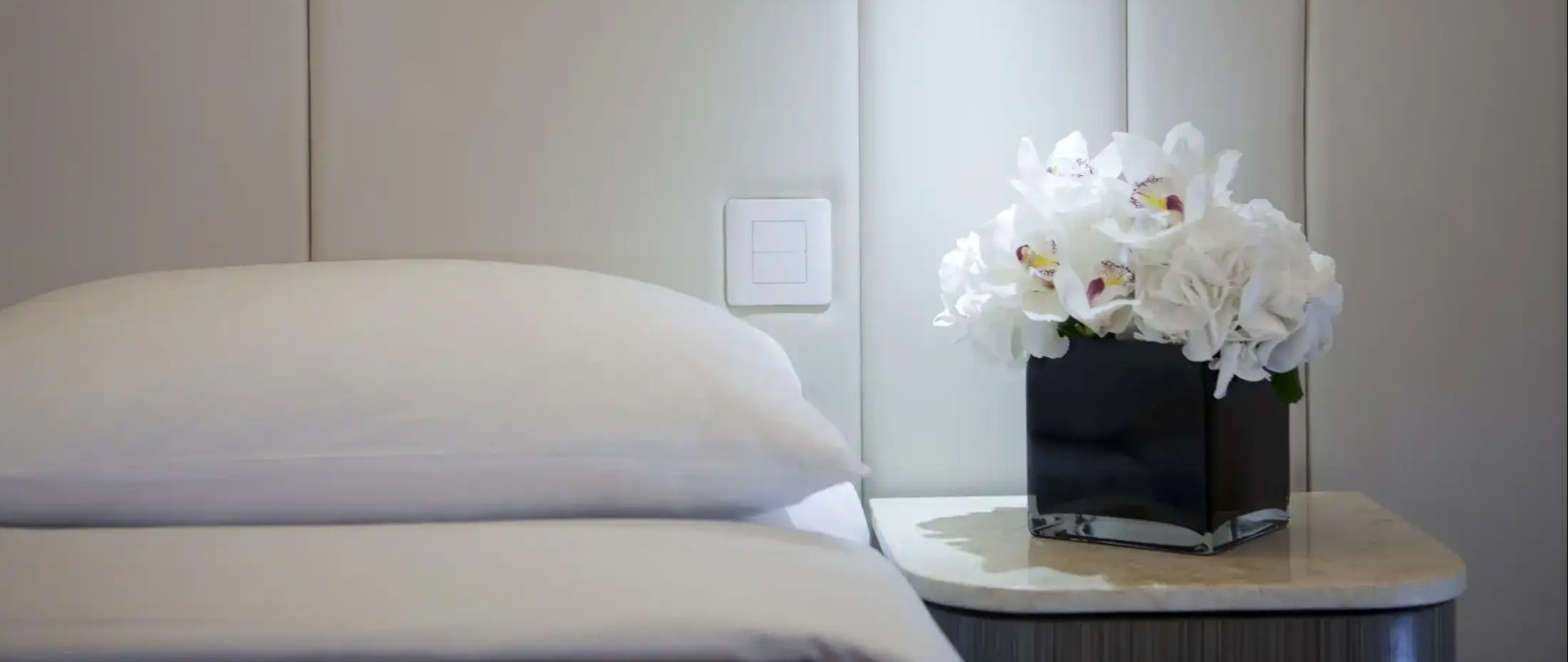 Bedside table with flowers at Silka Sea View Deluxe Room