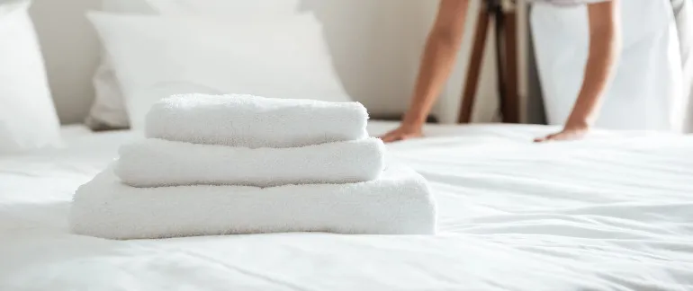 Neatly folded set of towels on a Silka Tseun Wan bed