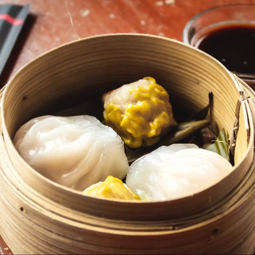 Authentic dim sum served in a container with soya source